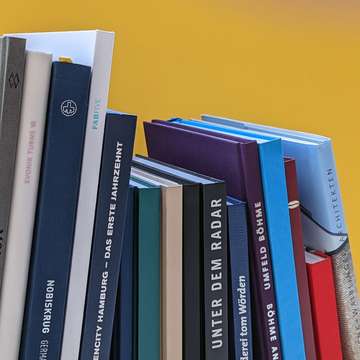 Bücherreihe vor gelbem Hintergrund Druckerei Hamburg