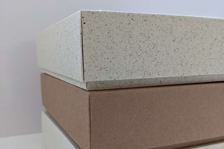 Faltschachteln aus Graspapier und braunem Karton Faltschachteln aus Graspapier und braunem Karton