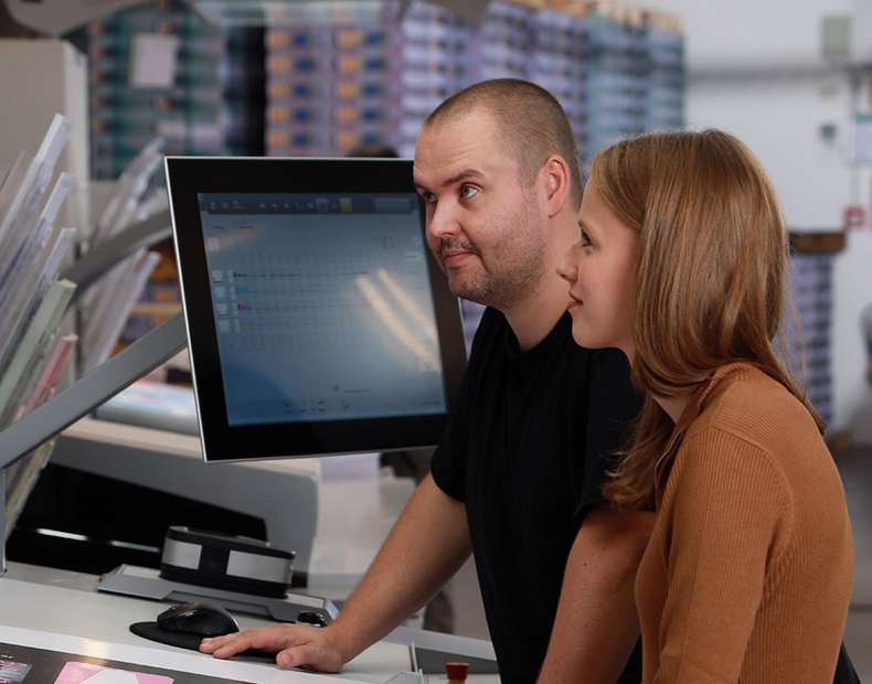 Zwei Menschen vor dem Drucktisch in Produktionshalle-ISO 90012015