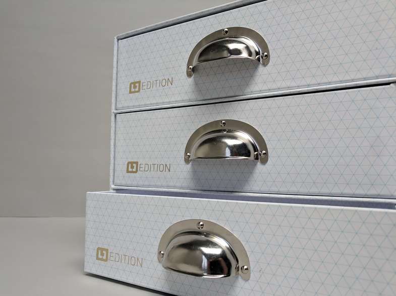 Ordnungssysteme und Aufbewahrungskartonagen Kartonage mit drei Schubladen, untere leicht geöffnet - Stehsammler Schuber