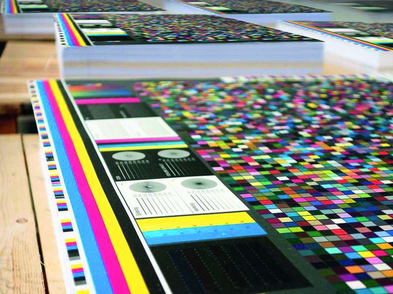 Druckbogen mit Farbauszügen auf Holztisch - ISO 90012015